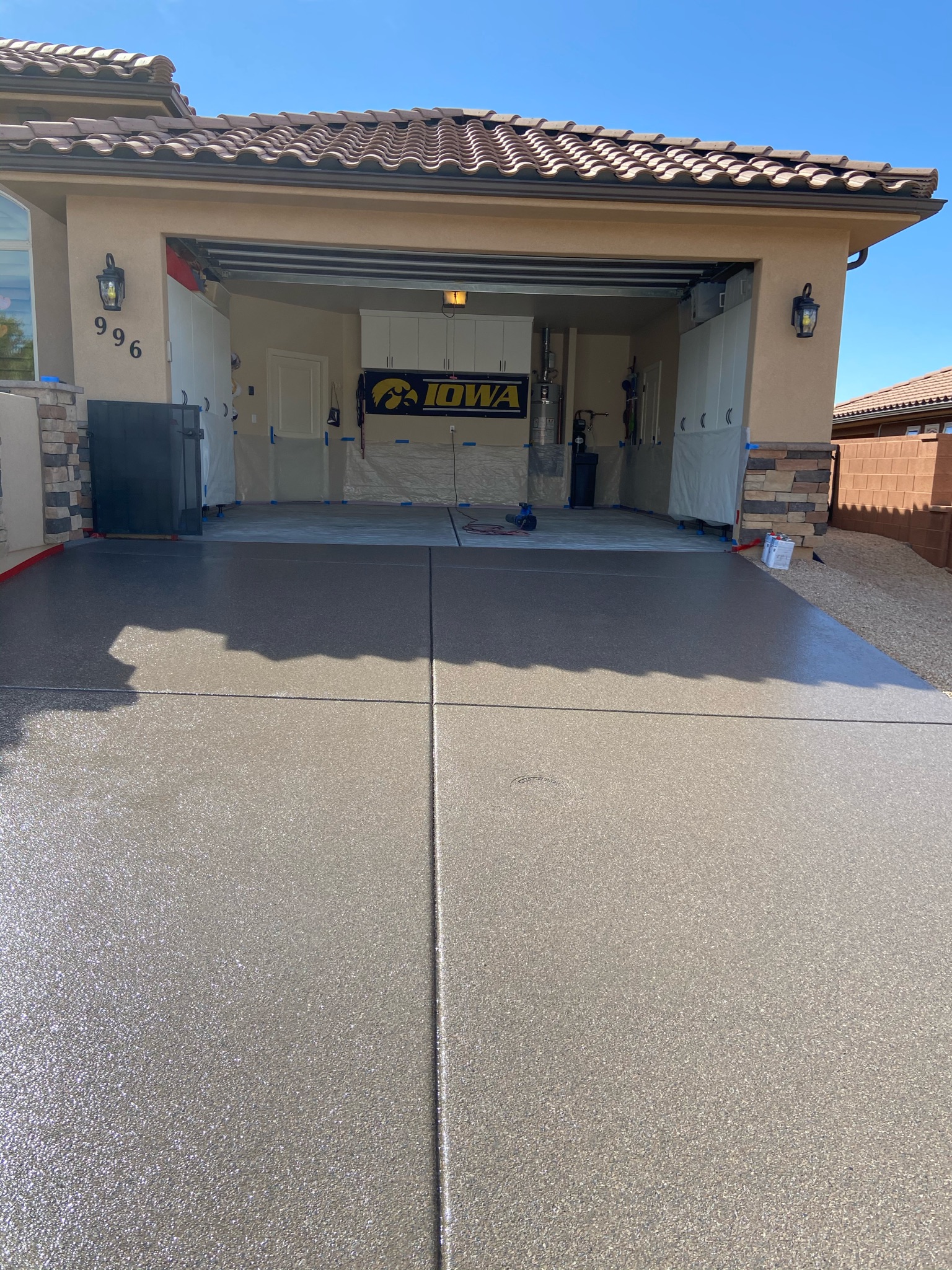 Dark gray driveway coating freshly installed in front of two-car garage - Sparks Coatings