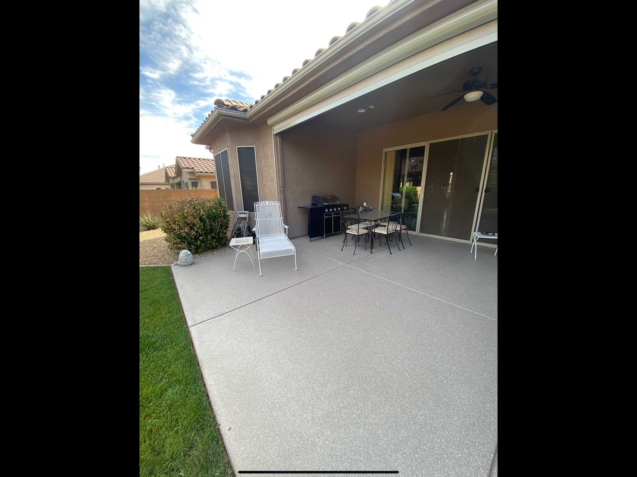 Light gray patio coating with outdoor dining and patio furniture - Sparks Coatings Utah