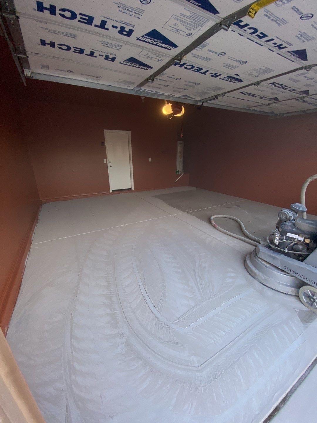 Active diamond grinding in progress on garage floor before coating application - Sparks Coatings